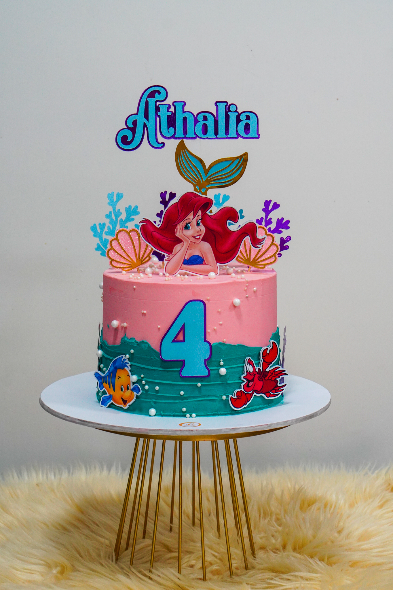 Little Mermaid-themed birthday cake with Ariel topper, seashells, and ocean decorations